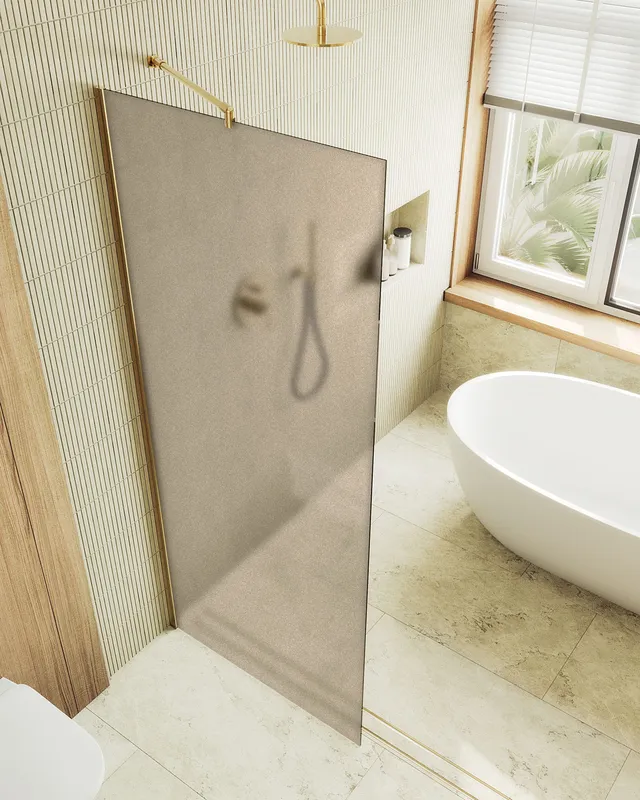 Душевая перегородка MaybahGlass в широком профиле, 195x1190 см, стекло бронза матовая/золотой — у бежевой стены с окном и ванной