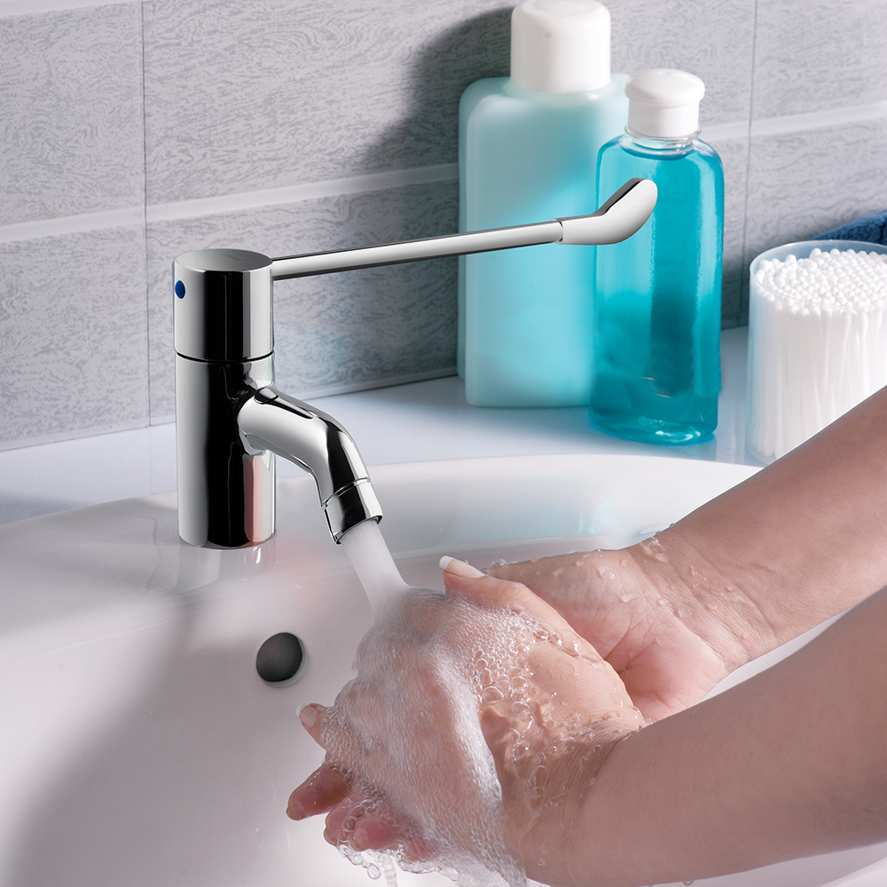 Смеситель для раковины Jaquar Florentine FLR-CHR-5033B — хромированный кран с текущей водой на фоне светлой плитки