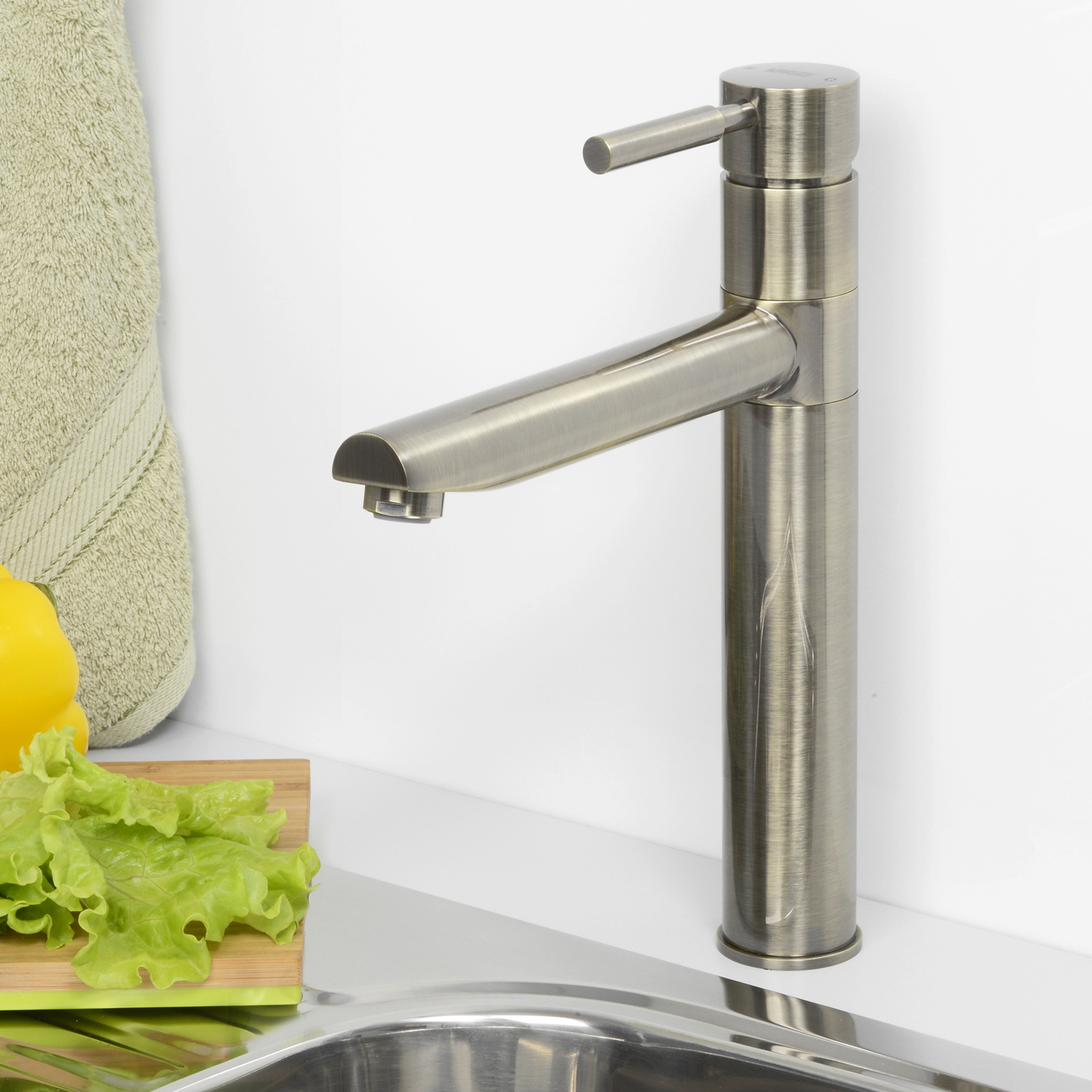 Смеситель для кухни Wasserkraft светлая бронза — на белой столешнице рядом с овощами и полотенцем
